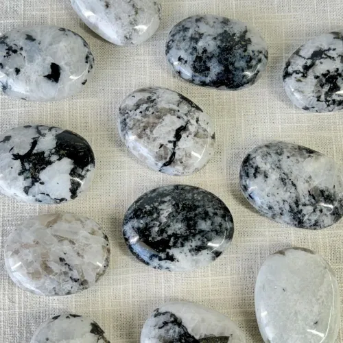 Close-up comparison of real moonstone versus imitation showing surface differences